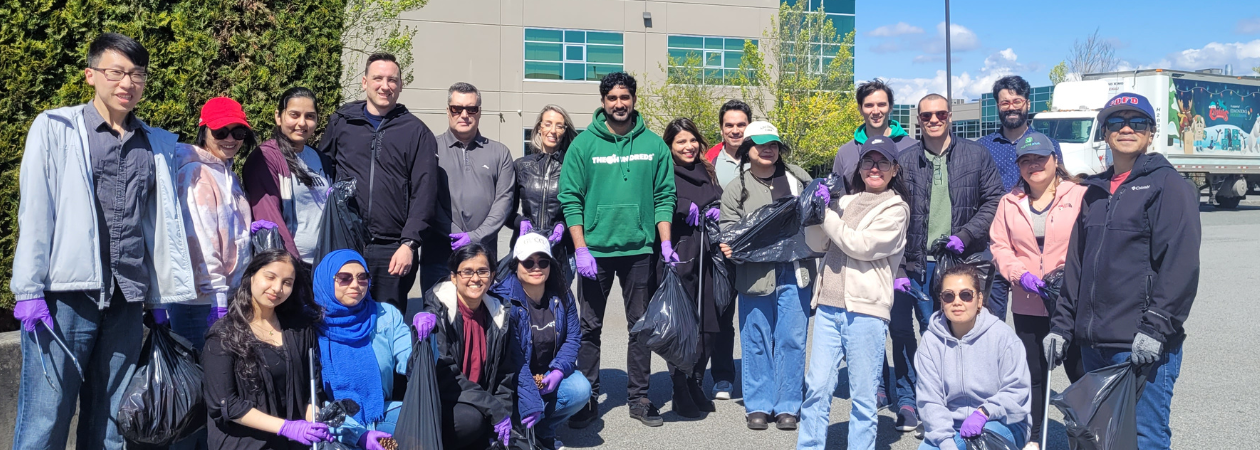 Imprint Plus team participating in a community clean-up for Earth Day 2025, collecting litter near the office and river trail