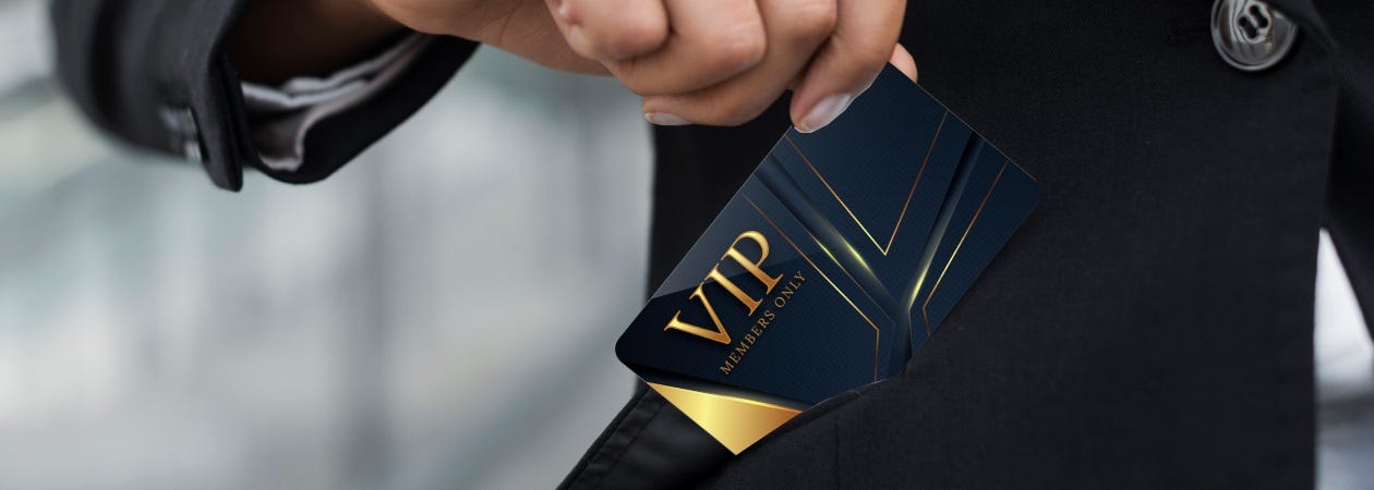 A person in a suit holding a business card, representing Membership Badges.