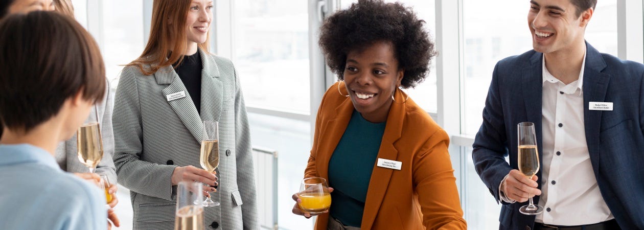 A group of professionals enjoying drinks at a business event, wearing plastic name badges.