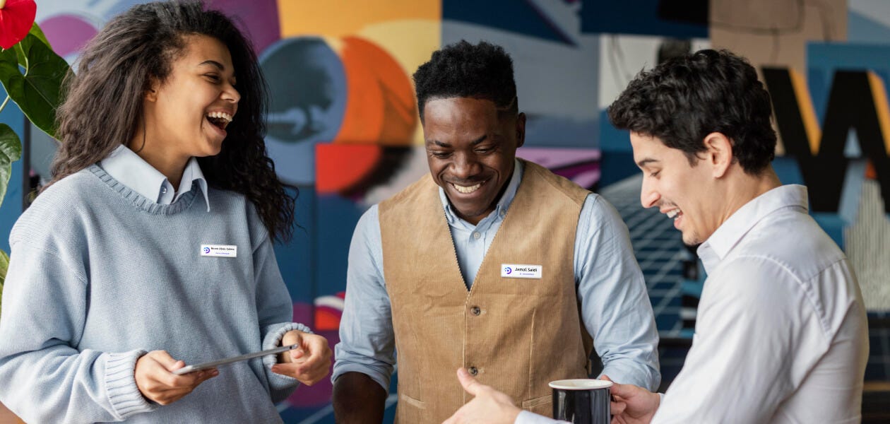 Group of coworkers engaged in conversation and enjoying a light moment at work.