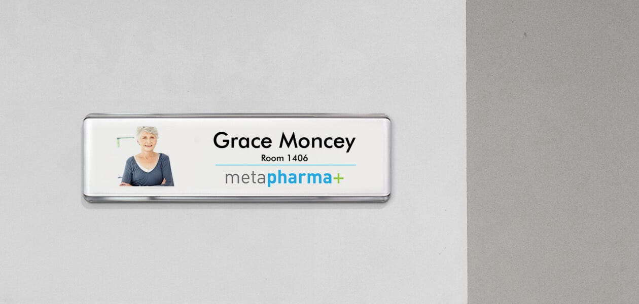 A wall name plate displaying the name of a pharmacy.