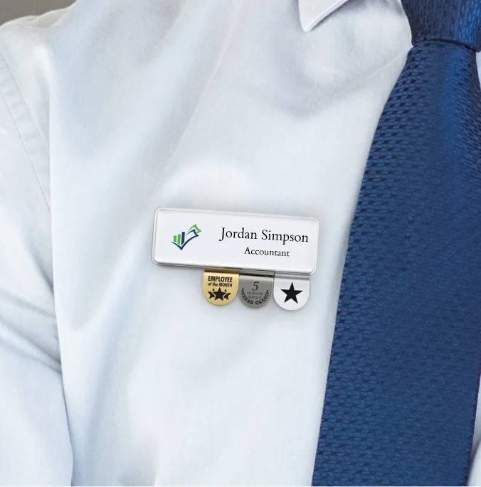 A professional man wearing a tie and a naem badge with medallions