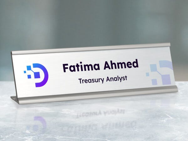 A close-up of a name plate with a polished metal surface and engraved name